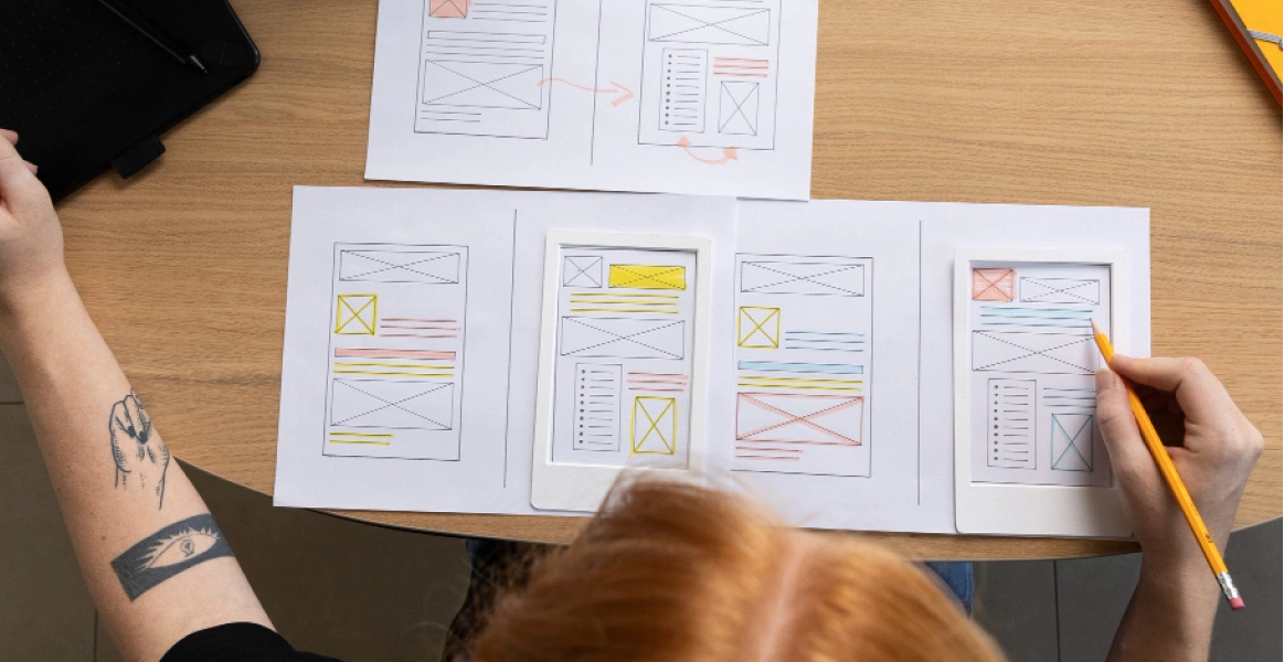 UI designer sketching mobile app wireframes on paper
